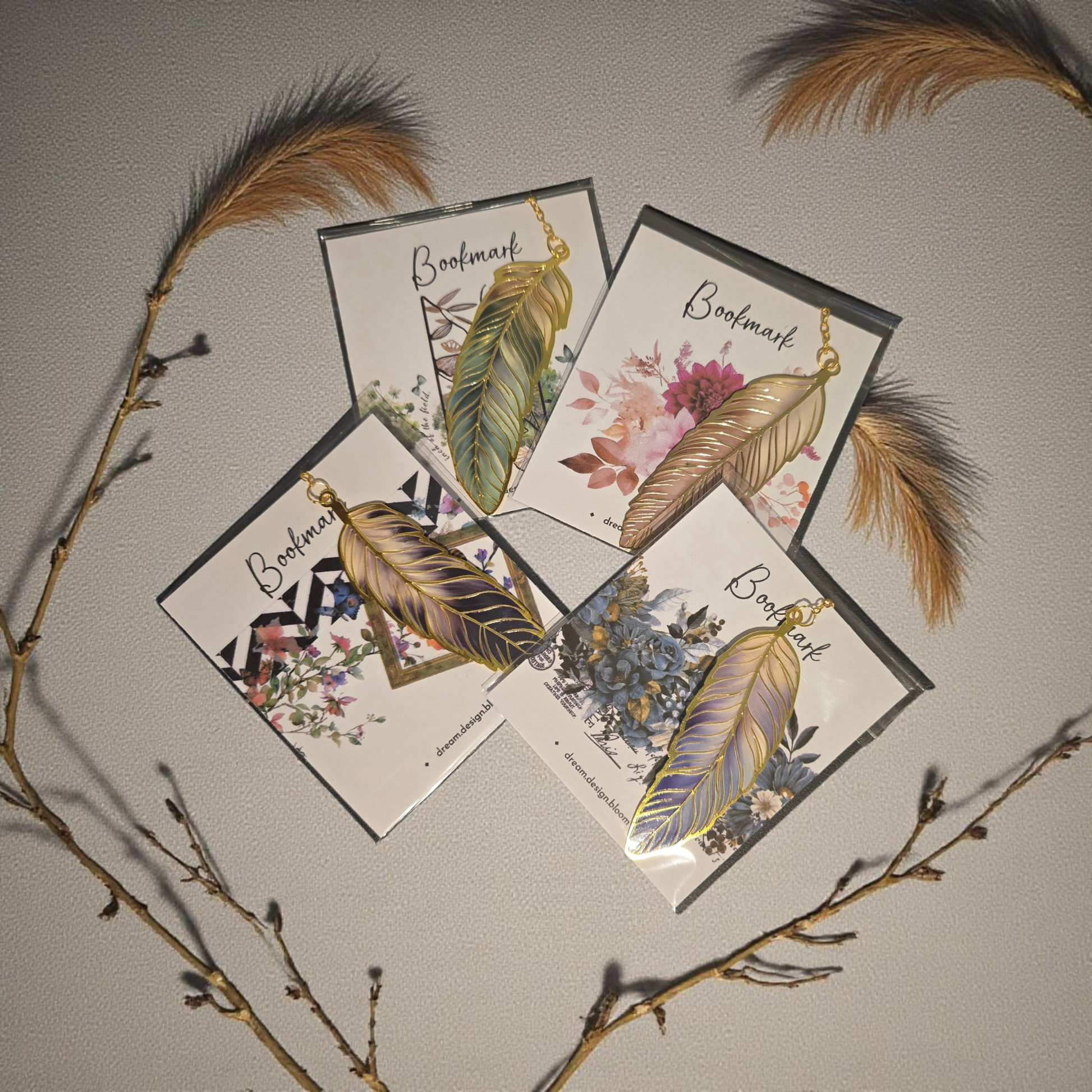 flatlay of gold feather planner bookmarks by dream.design.bloom featuring Whisper Dreams, Azure Blooms, Arbor Designs and Celestial Blooms colour palettes