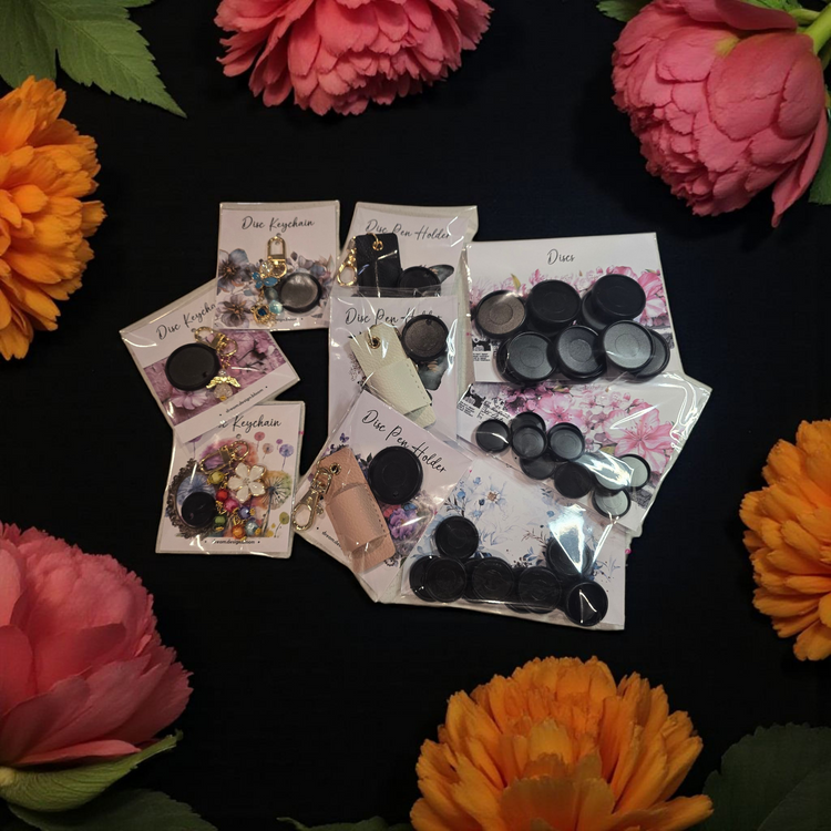 collection of dream.design.bloom discbound planner accessories including black discs, pen holders, and key charms designed to combine beauty, function, and creative organisation