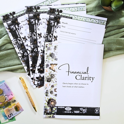 A set of floral and black-and-white budgeting and financial planning sheets titled 'Financial Clarity,' arranged on a light surface with a green fabric backdrop, alongside a gold pen, Australian banknotes, and green fruit. Disc Bound Planner. Discbound