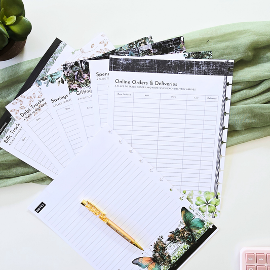 A styled flat-lay of a discbound planner notepad set with various budgeting, shopping, and tracking sheets, featuring a gold pen and a green fabric background. Disc Bound Planner
