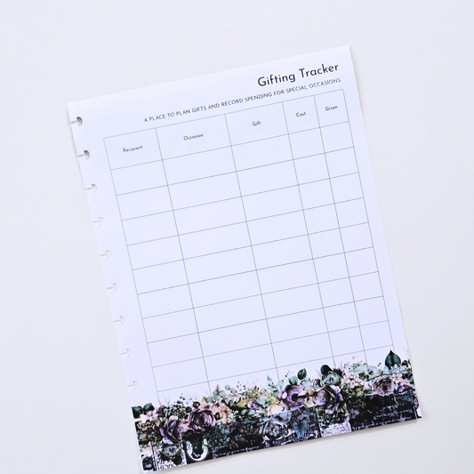 A white discbound Gifting Tracker planner inserts page with a floral border at the bottom, photographed on a clean white background. Disc Bound Planner.