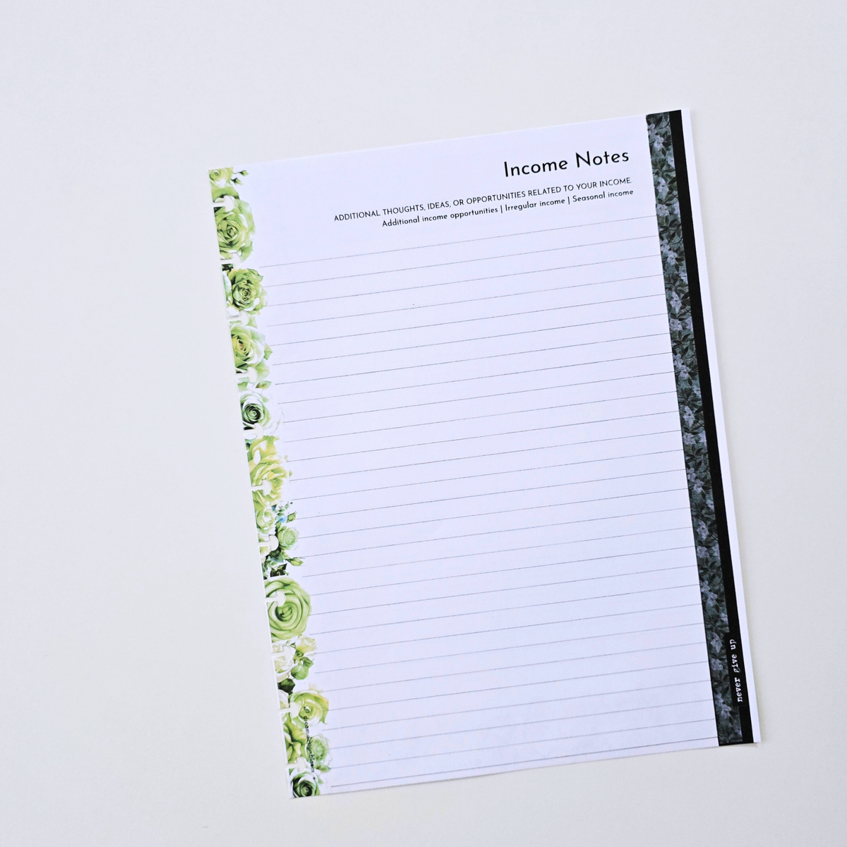 A lined income notes pad with green floral illustrations along the left margin and a dark patterned spine, photographed on a clean white background. Disc Bound Planner. Discbound Inserts