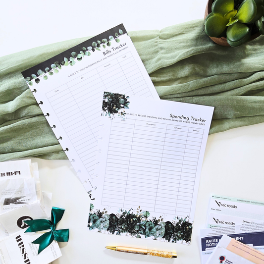 Two disc bound planner inserts, a Bill Tracker and a Spending Tracker, styled on a white surface with a sage green fabric backdrop, a gold pen, and small decorative props. Discbound Planner