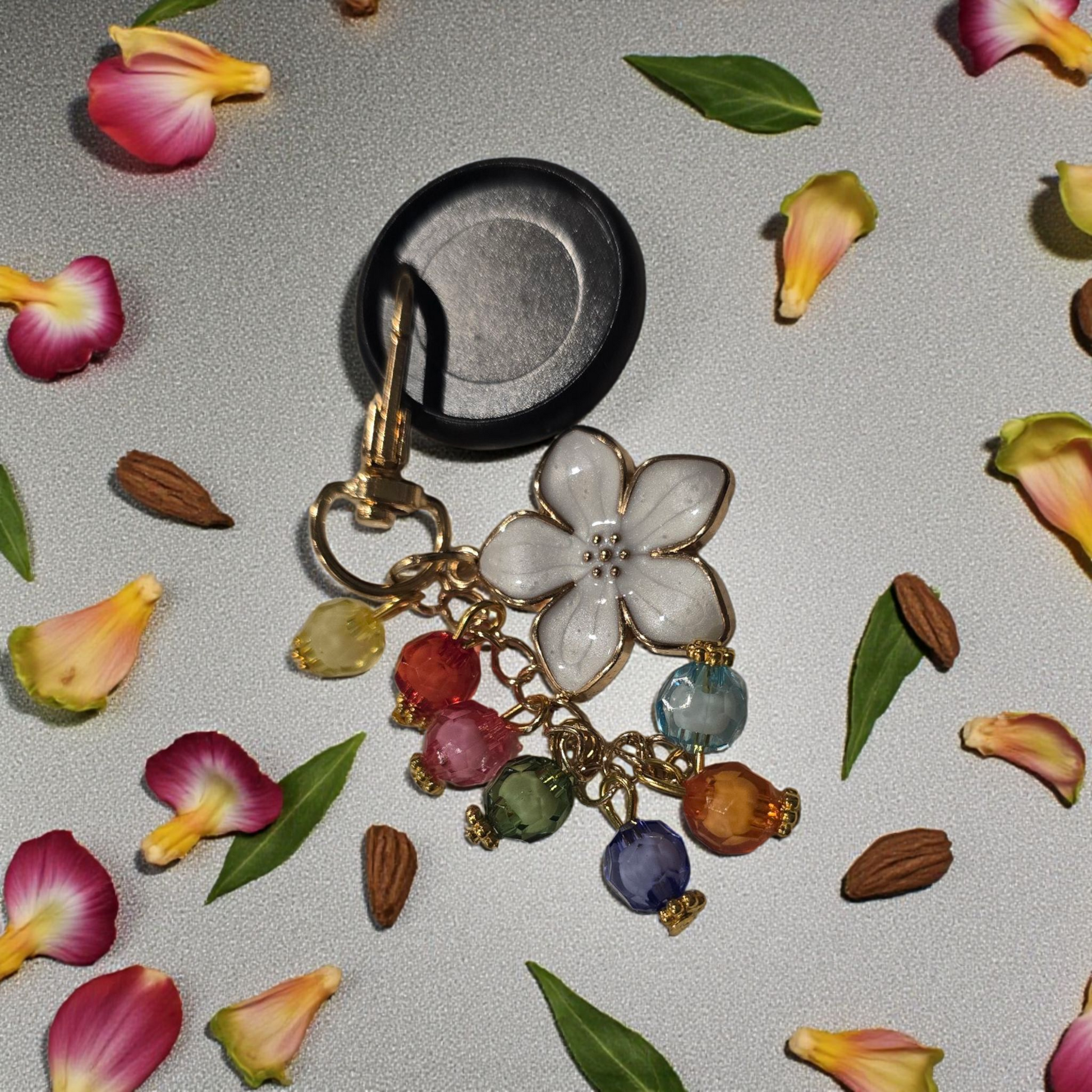 Celestial Blooms disc key charm by dream.design.bloom displayed on a black disc, colourful rainbow discbound planner accessory featuring a unique butterfly charm