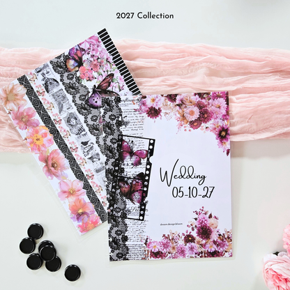 A styled flat-lay of discbound planner covers with floral and butterfly prints, black-and-white lace and stripe strips, and the name 'Wedding 05-10-2027' on one sheet. Pink fabric drapes behind the items, with black round discbound-discs on the left and the text '2027 Collection' at the top.